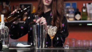 Kızıl saçlı genç bir kız. Yetişkin bir barmen. Karma uçak kokteyli hazırlıyor.