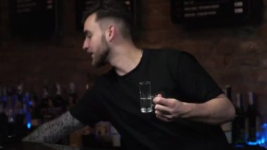 Barmen genç bir adam. Adam içki dolduruyor, içki hazırlıyor. Medusa 'yı barda hazırlıyor.