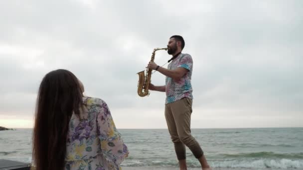 Fecha en el mar al amanecer Picnic Un hombre realiza una serenata para su amada — Vídeos de Stock