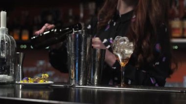 Kızıl saçlı kız. Genç yetişkin barmen barda kağıt uçak kokteyli hazırlıyor.