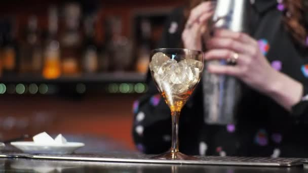 Pelirroja chica joven adulto mujer barman prepara mezclas de papel avión cóctel bar vierte campanas de hielo — Vídeos de Stock