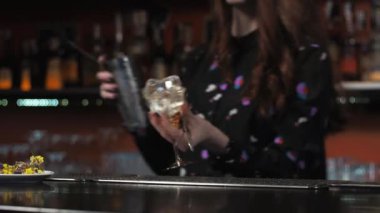 Kızıl saçlı kız. Genç yetişkin barmen barda kağıt uçak kokteyli hazırlıyor.