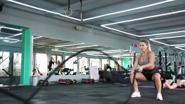 CrossFit Een blonde vrouw traint met touwen Stretches spieren Sporten — Stockvideo