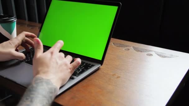 Homme assis dans un café derrière un ordinateur portable Travaillé ou des études, boit du café Décryptages Écran vert chroma key — Video