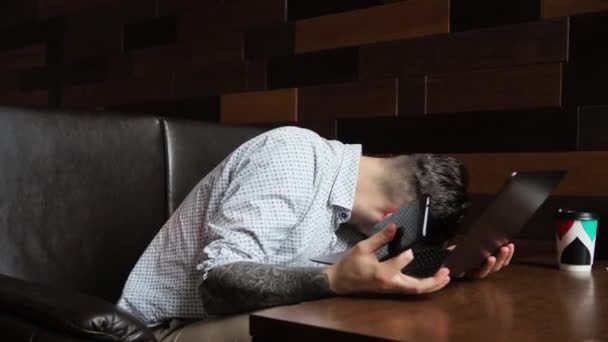 Человек сидит в кафе за ноутбуком Работающие исследования пьет кофе телефонный чат Счастливая улыбка смеха — стоковое видео