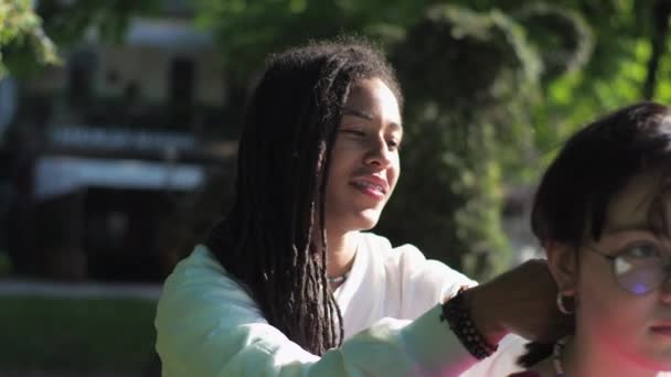 Eine Junge Afroamerikanische Mutter Mit Ihrer Weißen Tochter Sitzt Park — Stockvideo