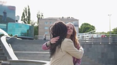 Young african american woman is meeting with a business partner or client and discussing future plans for a project, hugging her friend