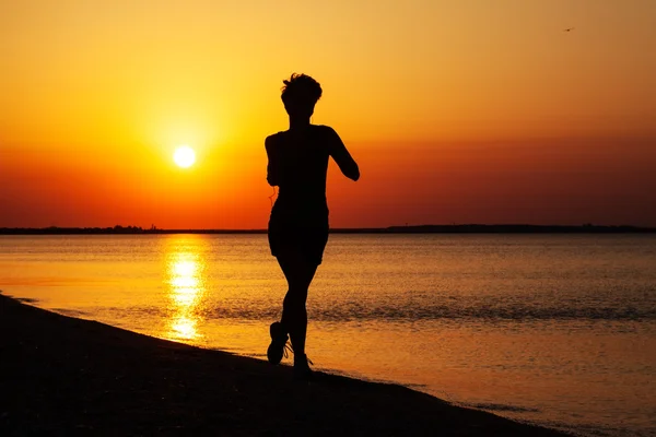Jong meisje loopt langs de kust van de zee — Stockfoto