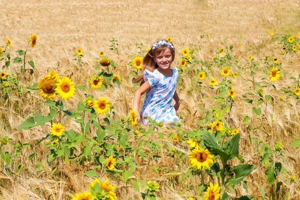 Gelukkig klein meisje uitvoeren in een veld — Stockfoto