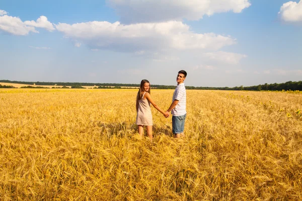 Junges Paar geht durch Weizenfeld — Stockfoto