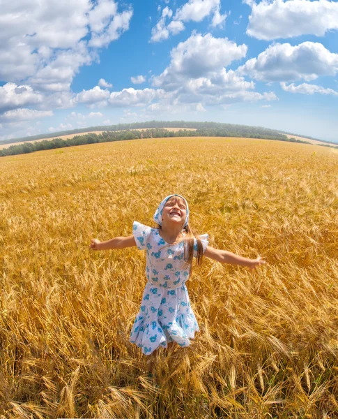 Glückliches kleines Mädchen, das auf einem Feld tanzt — Stockfoto