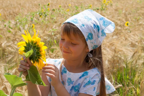 Mooi klein meisje en zonnebloem — Stockfoto