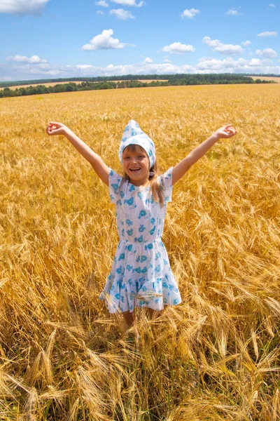 Glückliches kleines Mädchen, das auf einem Feld tanzt — Stockfoto