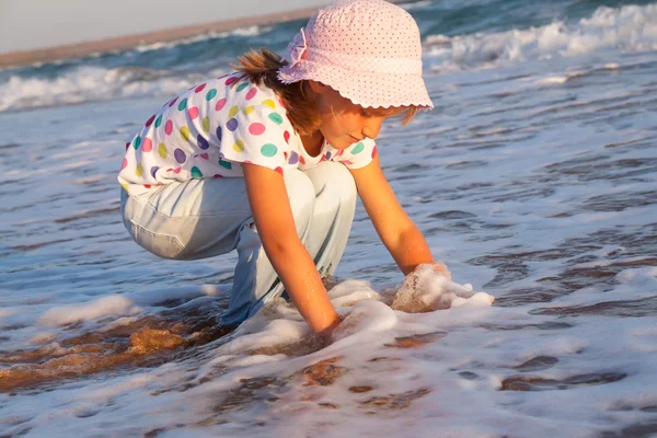 Lykkelig, aktivt barn som plasker og leker i havet . – stockfoto