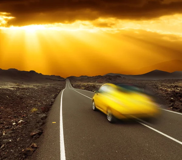 Sunset over fast car and road — Stock Photo, Image