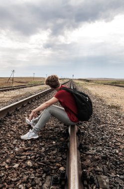 tren yolu üzerinde oturan sorunları olan genç kız