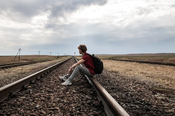 Teen girl with problems sitting on rail road — Stock Photo, Image