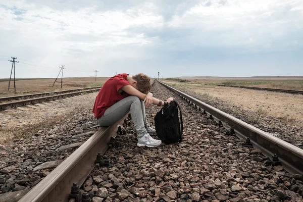 Teen girl with problems sitting on rail road — Stock Photo, Image