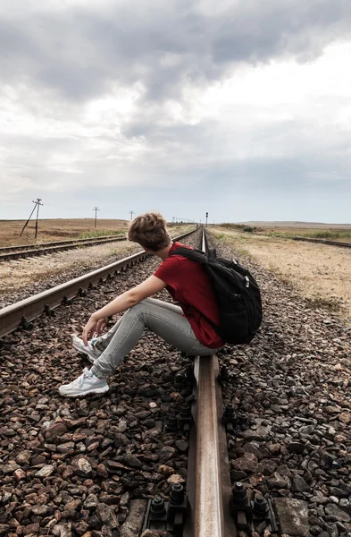 Дівчина-підліток з проблемами сидить на залізничній дорозі — стокове фото