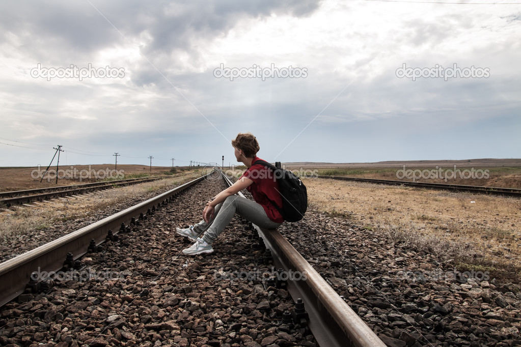 Teen girl with problems sitting on rail road