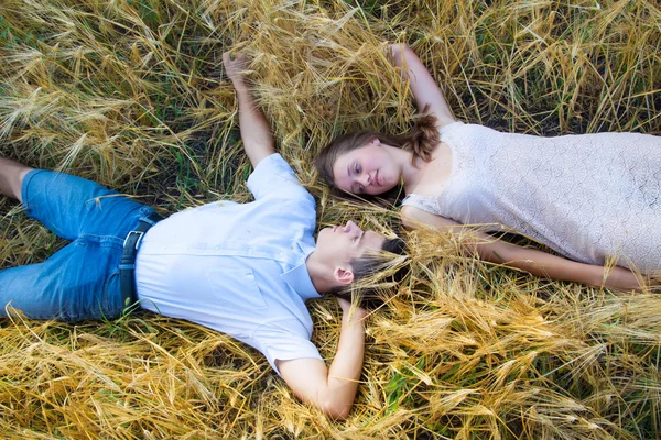 Glückliches lächelndes Paar entspannt sich auf dem Feld — Stockfoto