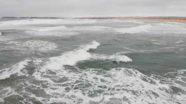 4k Havadan deniz dalgalarının görüntüsü sarı kumsalda kırılıyor