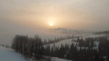 Kış sabahı bulutların üzerinde uçarak Karpat Dağları 'nda gün doğumunu.