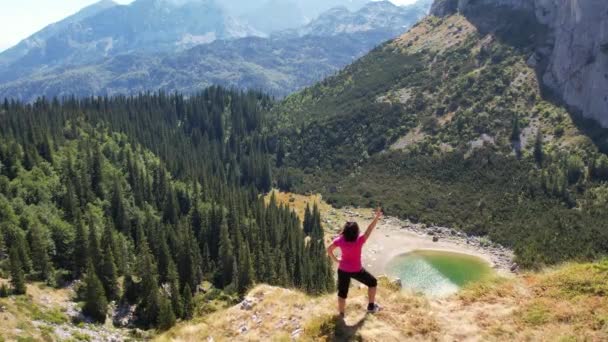 Drone vista para a mulher desportiva no topo da montanha. Desporto, vitória, conquistas — Vídeo de Stock