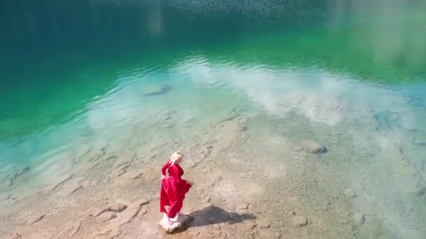 Woman in red dress near Black lake in Durmitor mountains — стоковое видео