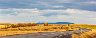 İzlanda karayolu manzarası. Bulutlar ve ufukta okyanus. Meşhur turistik cazibe