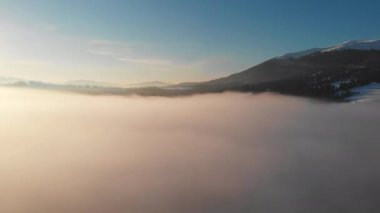Kış sabahı bulutların üzerinde uçarak Karpat Dağları 'nda gün doğumunu..