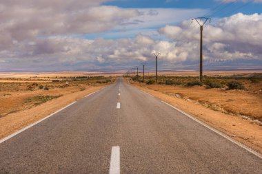 Endless asphalt road in dry stone Morocco desert clipart