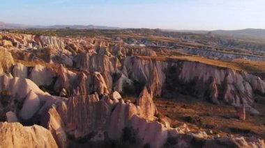 Kapadokya 'nın insansız hava aracı görüntüsü Red ve Rose Valley kaya oluşumunda günbatımına, antik mağara kiliselerine. Goreme, Kapadokya, Türkiye