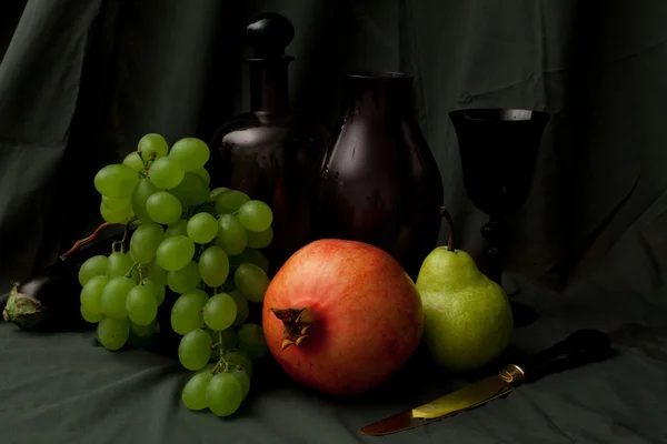 Still life with grapes, pomegranate, vine and gold knife — Stock Photo, Image