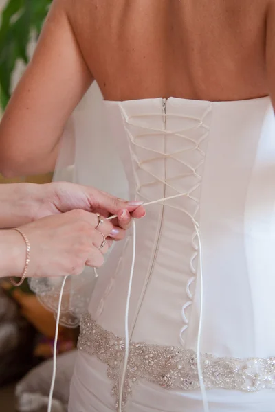 Lacing on the wedding dress close-up — Stock Photo, Image