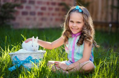 bir tavşan tavşan ile sevimli küçük kız bir Paskalya yeşil çim vardır.