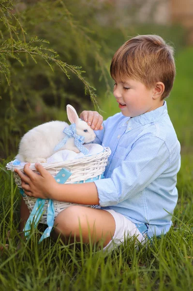 Schattig klein meisje met een konijn heeft een Pasen op groen gras — Stockfoto