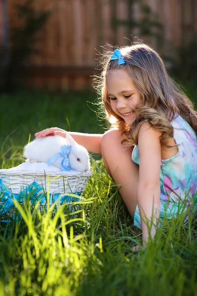 Cute little girl with a bunny rabbit has a easter at green grass — Stock Photo, Image