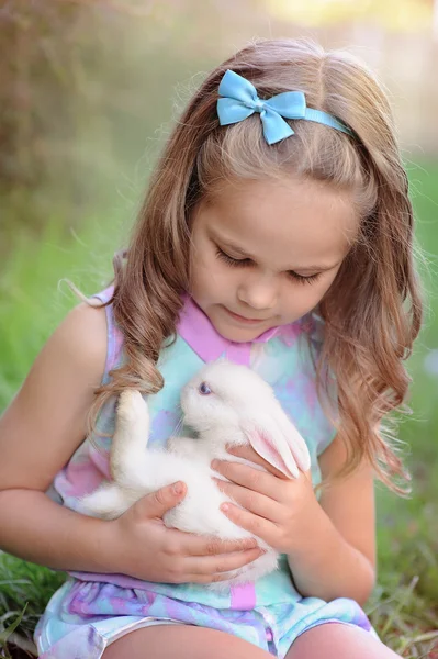 Roztomilá holčička s králíček má Velikonoce v zelené trávě — Stock fotografie