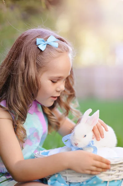 Linda niña con un conejo conejo tiene una Pascua en la hierba verde —  Fotos de Stock