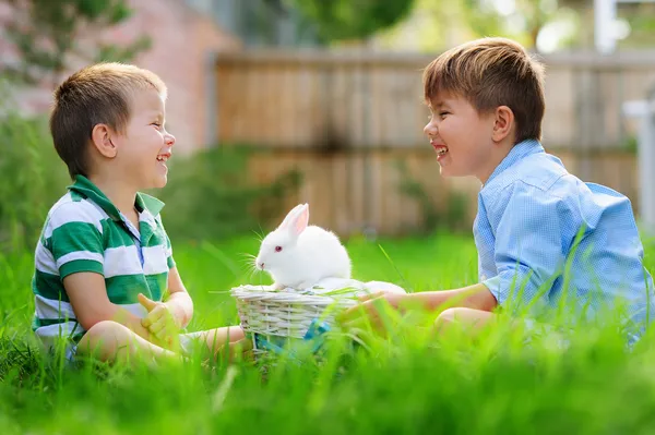Wo happy boys play with real easter bunny o — Stock Photo, Image