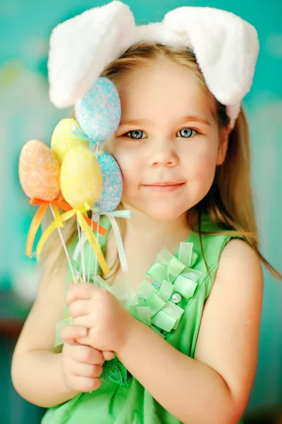 Linda niña con un conejo conejo tiene una Pascua en la hierba verde — Foto de Stock