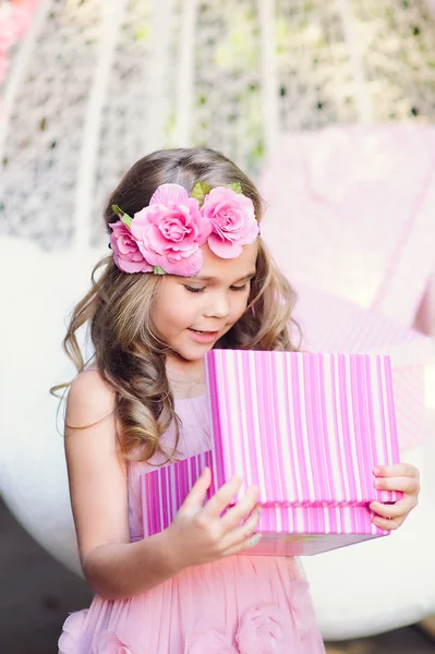 Süßes kleines Mädchen öffnet ihr Geburtstagsgeschenk Stockfoto