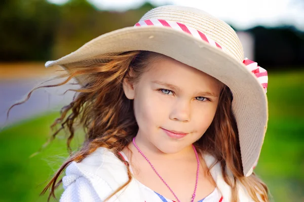 Πορτρέτο του ένα μικρό παιδί κορίτσι της μόδας σε ψάθινο καπέλο στο πάρκο Royalty Free Εικόνες Αρχείου