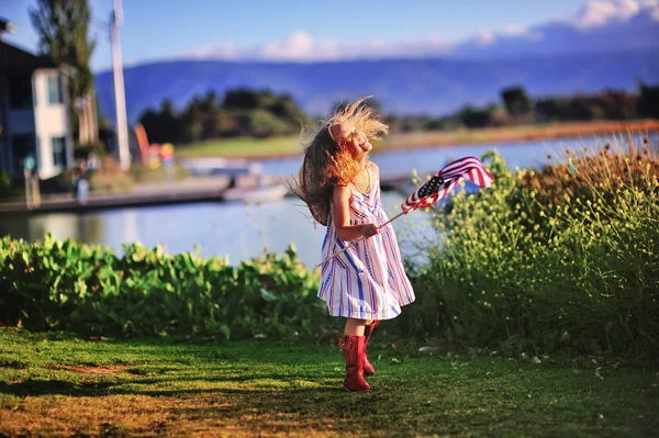 Kleines Mädchen schwenkt amerikanische Flagge lizenzfreie Stockbilder