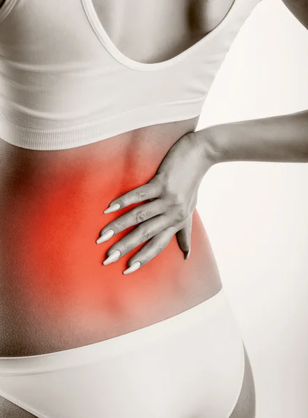 Mujer joven con dolor de espalda — Foto de Stock
