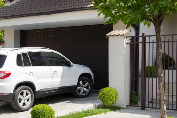 Witte auto voor het huis — Stockfoto