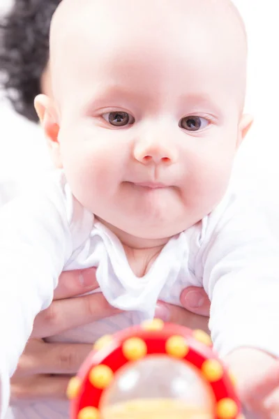 A baby reaches for toy — Stock Photo, Image
