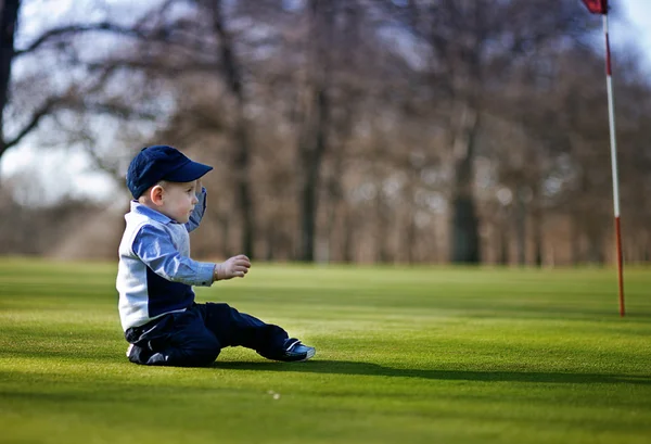 Ni:o en el campo de golf — стоковое фото