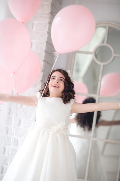 Niña bailando con los globos